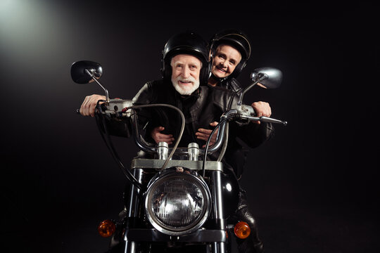 Portrait of old cool man drive chopper motor bike ride his wife enjoy free dome extreme lifestyle adventure wear vintage leather jacket isolated over black color background