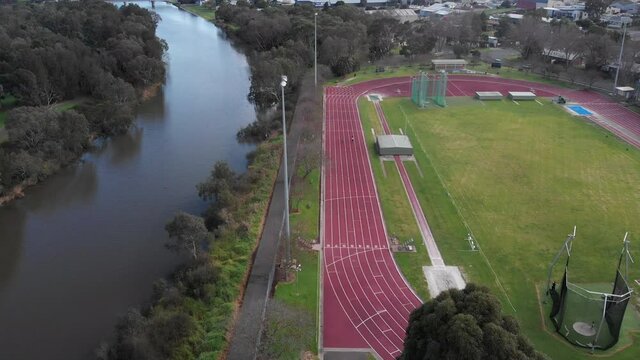 AERIAL Over Athletics Field Adjacent To A River