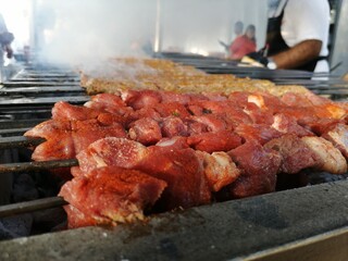 Shashlik preparing on a barbecue grill over charcoal. Shashlik or Shish kebab popular in Eastern Europe.
