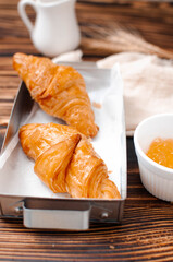 Croissant and jam on a rustic wooden table. Breakfast concept 