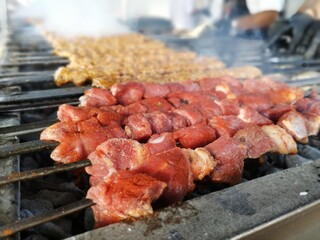 Shashlik preparing on a barbecue grill over charcoal. Shashlik or Shish kebab popular in Eastern...