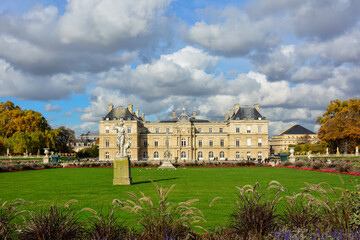 Colorful view of the Jardin du Luxembourg in Paris, France, with its flowerbeds and green lawns, on an autumn day. The Luxembourg Palace and its garden are a popular tourist attraction