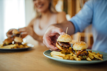 Friends eating delicious fast food, close-up.
