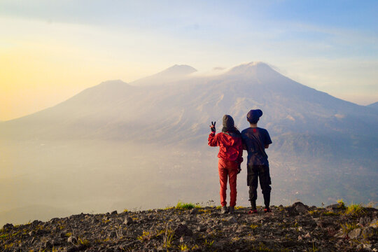 Friends Standing On Mountain Against Sky During Sunset