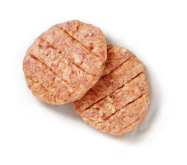 Raw hamburgers in a studio setting, on a wooden plank