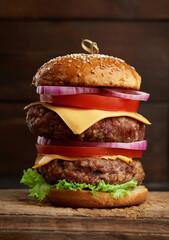 double cheeseburger with tomatoes, onions, barbecue cutlet and sesame bun