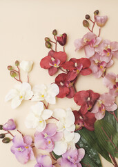 Obraz na płótnie Canvas artificial flowers orchids on beige background