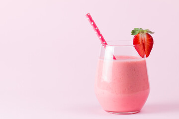 A glass of fresh strawberry smoothie on a wooden background. Summer drink shake, milkshake, juice and refreshment organic concept.