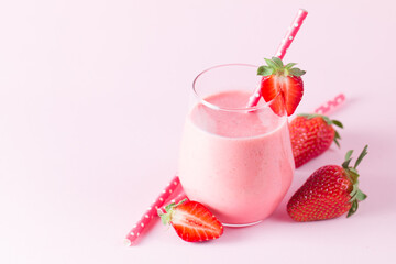 A glass of fresh strawberry smoothie on a wooden background. Summer drink shake, milkshake, juice and refreshment organic concept.
