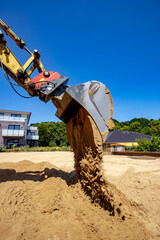 Gelber Bagger mit Baggerschaufel für Sand