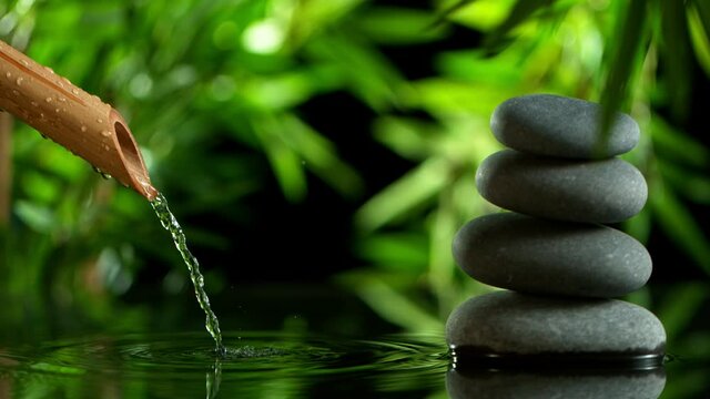 Super slow motion of leaking water stream from bamboo, spa and wellness concept. Filmed on very high speed cinema camera, 1000 fps.