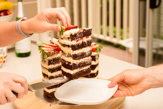 Delicious Handmade Double Barrel Tall Layered Cake Decorated With Strawberries On A Cake Stand. Cutted Slice Being Served