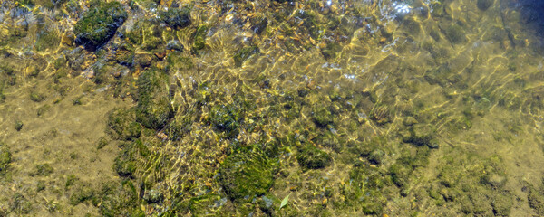 Glare of the sun and waves at the bottom of the river