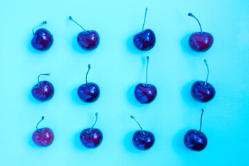Neon bright blue cherry on a ultraviolet background