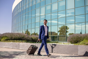 Obraz premium Young executive businessman walking around the airport for work trip
