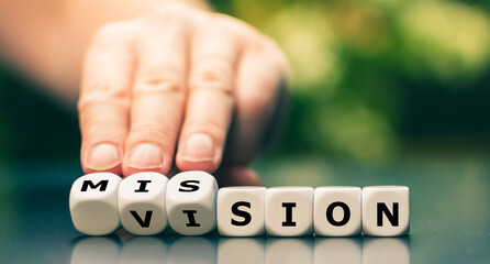 From a vision to a mission. Hand turns dice and changes the word vision to mission. - obrazy, fototapety, plakaty