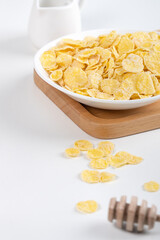Corn flakes bowl sweeties with milk and orange on white background, close up, fresh and healthy breakfast design concept.