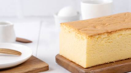 Plain classic Taiwanese traditional sponge cake (Taiwanese castella kasutera) on a wooden tray background table with ingredients, close up.