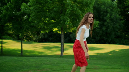 Mother talking with daughter in park. Woman and girl playing frisbee in meadow