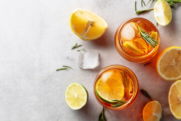 Traditional iced tea with lemon, lime and ice garnished with rosemary twigs.
