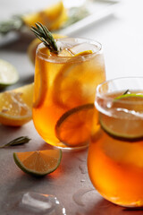 Traditional iced tea with lemon, lime and ice garnished with rosemary twigs.