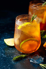 Traditional iced tea with lemon, lime and ice garnished with rosemary twigs.