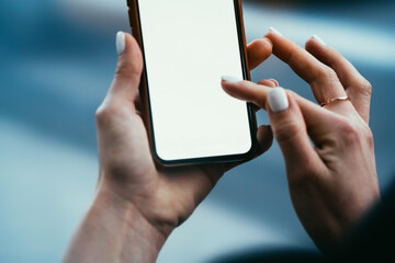 Cropped view of young woman's hands holding digital smartphone and typing with finger text message on blank display of device using high speed 4G internet connection for online chat