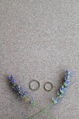 Gold wedding rings and lavender flowers. Top view. 