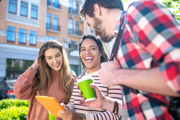 white-toothed smile showing tablet to friends
