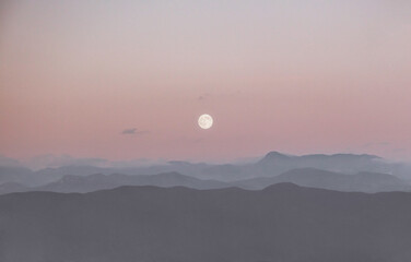 Full moon and the silhouettes of mountains
