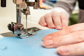 Woman sews on a sewing machine