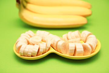 A banch bananas on wooden cutting board for cooking isolated on yellow background with copy space