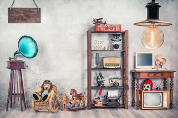 Still life with antique gramophone, old Teddy bear, rocking horse, collection of outdated media...