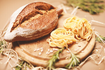 view from the top on fresh homemade bread with fettuccine and rosemary on wooden cutting board 
