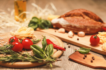 close up view on bread with red pepper,garlic,basil,spaghetti,sunflower oil and rosemary on wooden board.