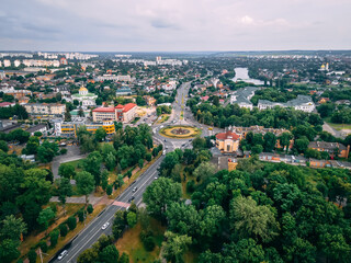 Aerial view of roundabout road with circular cars in small european city at summer afternoon
