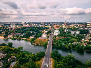 Fototapeta na wymiar Aerial view of two old churches near river and bridge in small european city