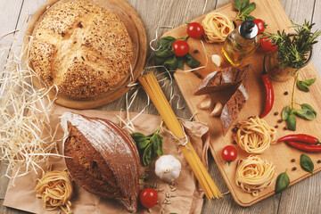 close up view on bread with tomato and rosemary, garlic,basil,spaghetti,sunflower oil and rosemary on background 