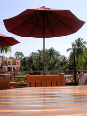  India  outdoor cafe , wooden tables protect umbrellas from the scorching sun