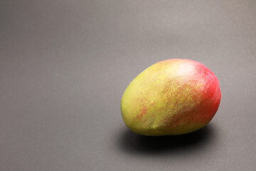 close up view of one fresh mango isolated on gray background 