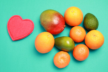Fresh mix of tropical fruits. Mango, oranges and avocado isolated on gray background with copy space