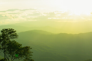 Sunset and mountains interspersed with green grass