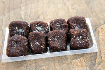 some chocolate sweets put in a glass tray on stone background