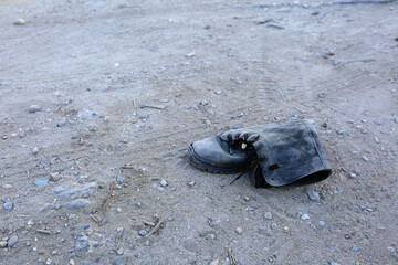 Old dusty shoe on the road