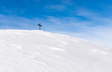Naklejka na ściany i meble Lonely Summit Cross on windswept snow mountain with blue Sky. Rangiswanger Horn, Alps, Allgau, Bavaria, Germany.