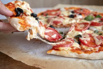 take a slice of homemade pizza with melted cheese and tomatoes