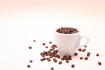 Cup of coffee beans inside isolated on a light pink background with copy space.