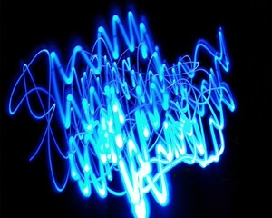 Light painting design. Combination of sky blue and white light against a black background 