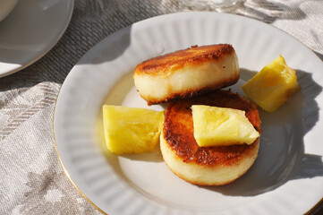 Tasty cheese pancakes with pineapple slices