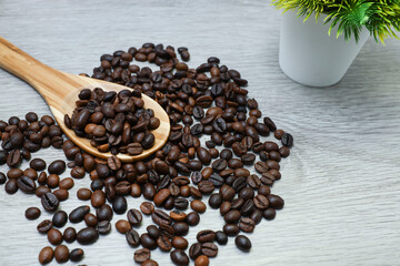 coffee beans in wooden spatula on wooden table